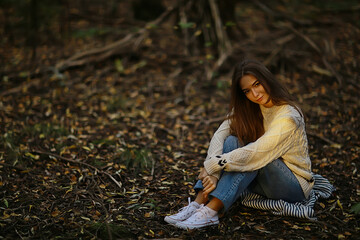 Wall Mural - girl sitting autumn park, autumn season september in the forest