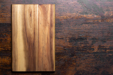 Wall Mural - Cutting board on wood kitchen table. Food recipe concept at wood background texture with copy space.