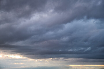 Wall Mural - Dark rain clouds in the evening sky. Dramatic sky with an coming cloudy cyclone of bad weather