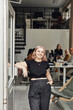 © Maskot - Portrait of smiling businesswoman standing by door at tech start-up office