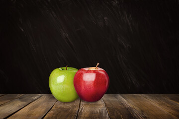 Wall Mural - Fresh ripe apples on wooden table near black chalkboard, space for text