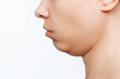 Cropped shot of a young caucasian woman's face with double chin isolated on a white background. Overweight, flabby and sagging skin. Profile