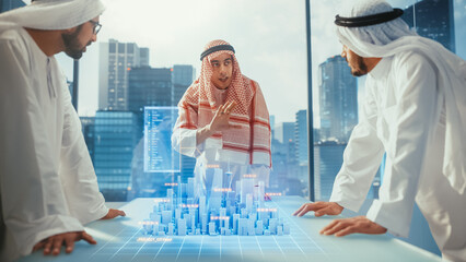 Group of Muslim Real Estate Business Developers in Traditional Clothes Discuss Investing Opportunities Based on Holographic Augmented Reality 3D City Model in Their Modern Office in a Skyscraper.