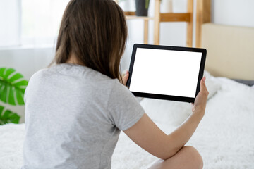 Canvas Print - Video conference. Casual woman. Computer mockup. Unrecognizable lady looking tablet computer with blank screen sitting bed in light room interior.