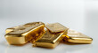 Several different gold bars lie on a pile of gold pellets. Selective focus.