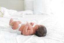 Newborn Baby Sleeping With Blanket On White Bed. Newborn Laying On White Bed.