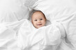 © Lisa Tichané - Happy newborn baby peeking from white sheet
