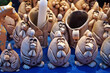 Decorative clay roosters stand on a counter at a Christmas market on a winter day