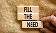 Fill the need symbol. Concept words Fill the need on wooden blocks on a beautiful canvas table canvas background. Businessman hand. Business, finacial and fill the need concept. Copy space.