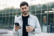 © uflypro - Attractive caucasian armenian young bearded man walks down the street uses phone smile sunlight sunset cellphone fashion internet face outside technology city mobile summer happy