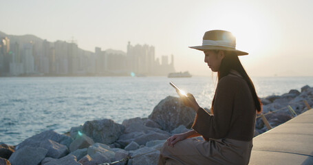 Wall Mural - Woman look at the cellphone under sunset light