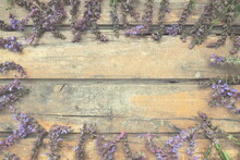 Lavender And Sage Flowers On A Wooden Table Close-up. Horizontal Boards Of Dark Old Wood With Purple And Blue Flowers And Leaves All Around. Still Life And Flat Lay. Free Space For Text. Copy Space.