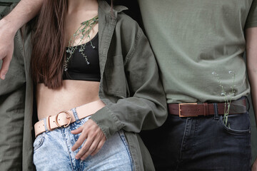 Close up portrait of couple men and woman with fashion leather belts and jeans. Casual urban style. Clothing and accessories for a man and a woman.