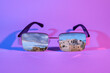 Leinwandbild Motiv Stylish sunglasses with reflection of old city on purple background