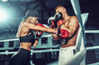 © zamuruev - Two sportsmans, woman and man boxers fighting in gloves. Boxing and fitness concept