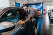 © hedgehog94 - Good looking man buying a new car at the car showroom.