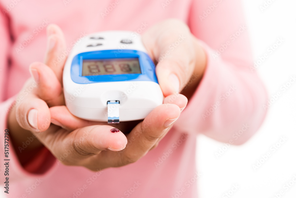 Closeup hands woman measur glucose test level check with blood on finger by glucometer she monitor and control high blood sugar diabetes and glycemic health care concept isolated on white background