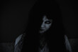 © sorapop - Asian woman ghost or zombie horror creepy scary close up she face and hair covering the face her eye looking to camera at night, Halloween day concept, in dark tone