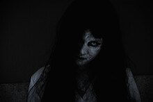 Asian Woman Ghost Or Zombie Horror Creepy Scary Close Up She Face And Hair Covering The Face Her Eye Looking To Camera At Night, Halloween Day Concept, In Dark Tone