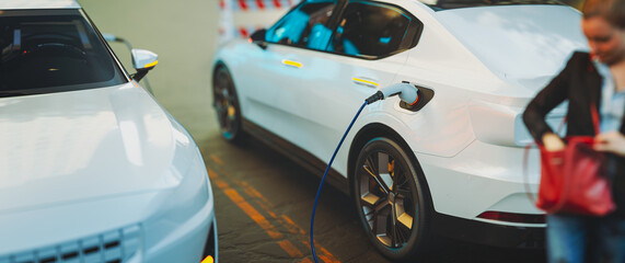 Wall Mural - EV Electric car silhouette with low battery charging at electric charge station.