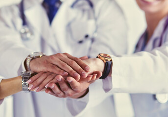 Wall Mural - Doctors and nurses in a medical team stacking hands