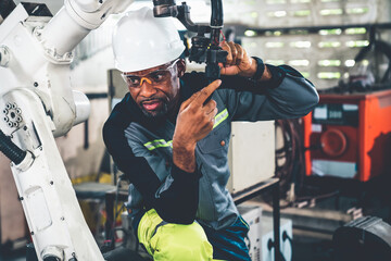 Poster - African American factory worker working with adept robotic arm in a workshop . Industry robot programming software for automated manufacturing technology .