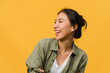 © tirachard - Portrait of young Asia lady with positive expression, smile broadly, dressed in casual clothing over yellow background. Happy adorable glad woman rejoices success. Facial expression concept.