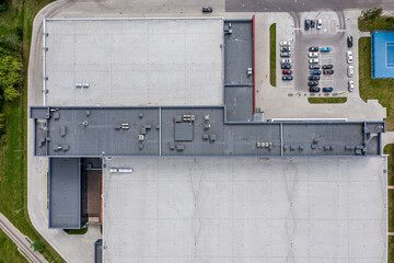 Wall Mural - aerial view of warehouse shingle roof and parking lot with parked cars