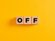 The word off on wooden cubes on yellow background.