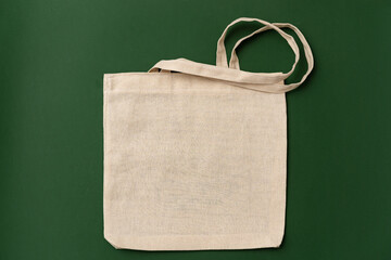 Wall Mural - Textile shopping bag on green background flat lay