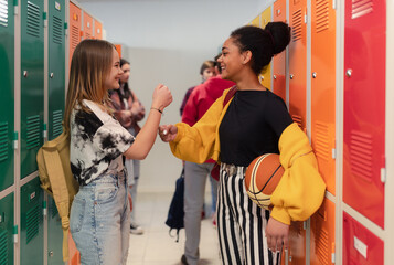 Sticker - Young high school students meeting and greeting near locker in campus hallway, back to school concept.