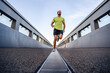 © Westend61 - Young man running on footbridge