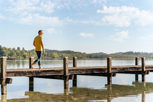 Man Walking On Pier At Lake