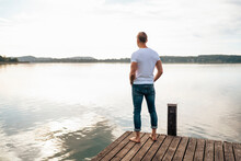 Man Looking At View From Pier Over Lake