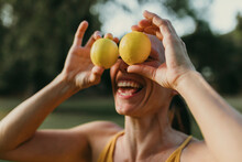 Cheerful Woman Covering Face With Lemons