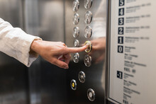 Hand Of Businesswoman Pressing Elevator Button