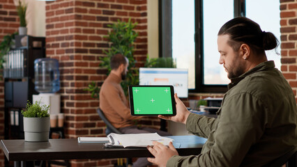 Poster - Male freelancer using horizontal greenscreen display on tablet, looking at blank chroma key template with isolated mockup background and copyspace. Digital gadget with technology.