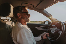 Mature Man Wearing Sunglasses Driving Car