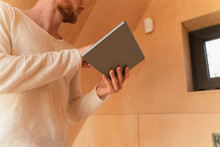 Man Setting Up A Smart Home Unit With Digital Tablet In Eco Home