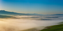 Italy, Tuscany, Volterra, Panoramic View Of Rolling Landscape Shrouded In Thick Morning Fog