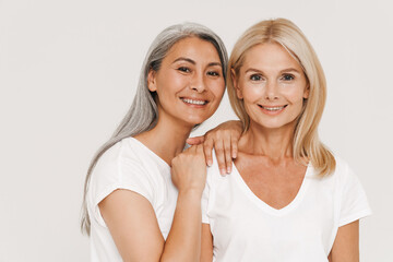 Mature happy multiracial women wearing t-shirts posing at camera