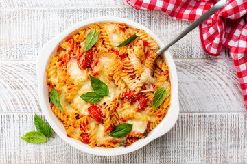 Pasta alla sorrentina.  Spiral shape fusilli pasta oven baked in casserole with tomato sauce, basil and mozzarella, parmigiano  cheese. Italian meal, Campania region.