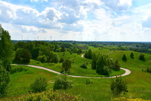 A View Of An Asphalt Road Leading Uphill Towards The Top Of A Hill Or Mountain, With Trees, Herbs, Shrubs And Other Flora Seen On Both Sides On A Cloudy Yet Warm Day In Poland Spotted During A Hike