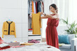 © StockPhotoPro - Woman choosing clothes in her bedroom