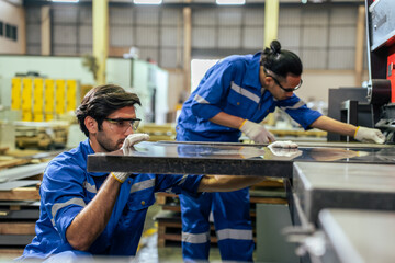 Wall Mural - Asian and Caucasian male industrial worker work in manufacturing plant