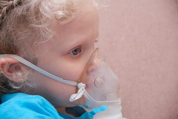 cute caucasian girl is ignited using a nebulizer