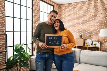 Poster - Young couple moving to a new home smiling and laughing hard out loud because funny crazy joke.