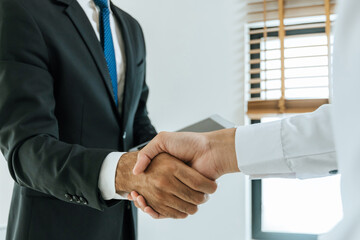 Wall Mural - Deal. business people handshake after business signing contract document on desk in meeting room at company office, partnership, job interview, investor, negotiation, partnership and teamwork concept