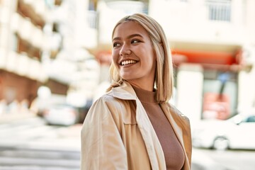 Poster - Young blonde girl smiling happy standing at the city.