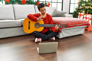 Sticker - Hispanic woman with short hair learning classical guitar from online tutorial with open hand doing stop sign with serious and confident expression, defense gesture